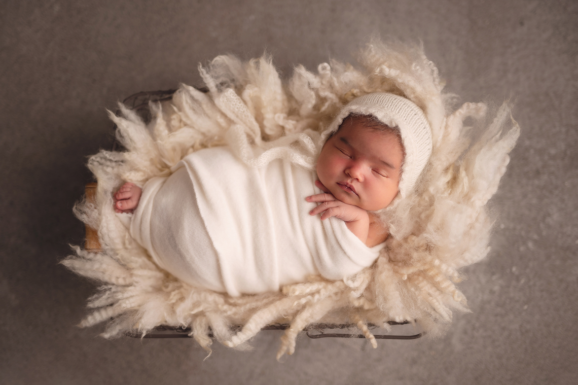 newborn baby girl in the wire basket