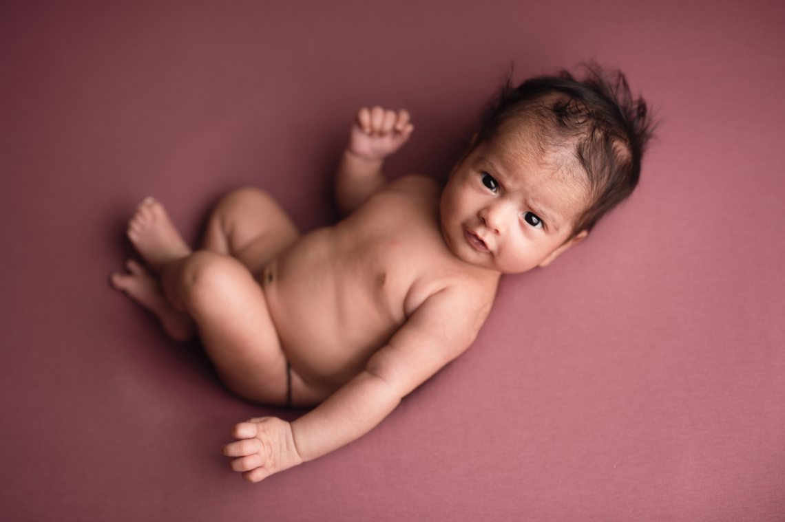 baby girl seven weeks old on the pink backdrop
