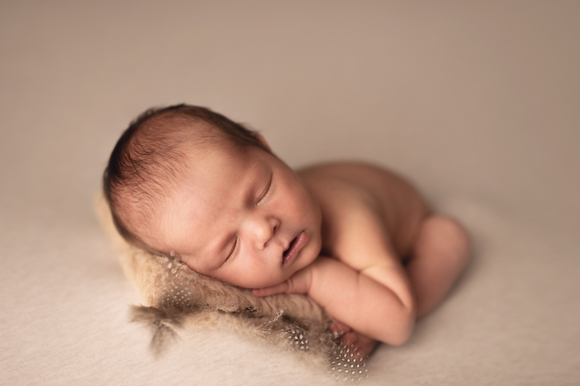 newborn baby boy in the prop in beige color