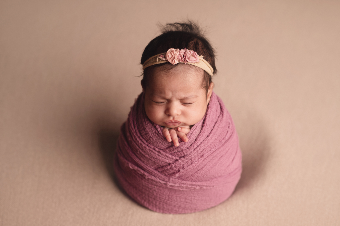 indian seven weeks old baby girl wrapped in pink fabric