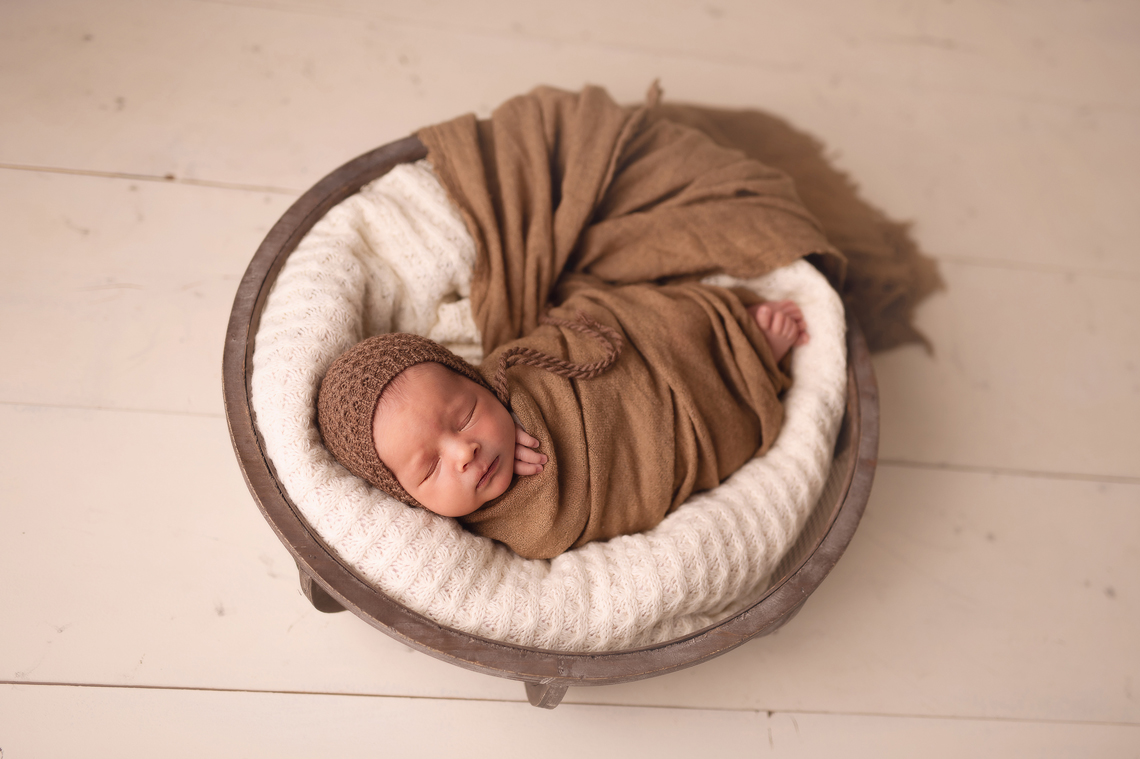 newborn baby boy in the prop in beige color