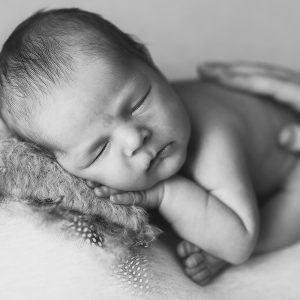 newborn baby boy on the pillow with hand under the cheek