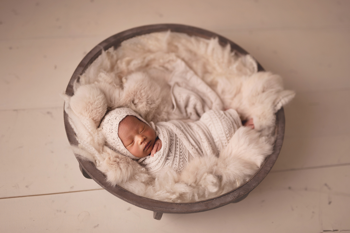 newborn baby girl wrapped and lying in the prop