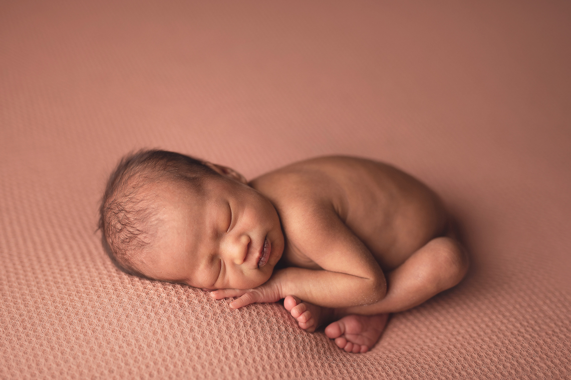 newborn baby girl in womb pose